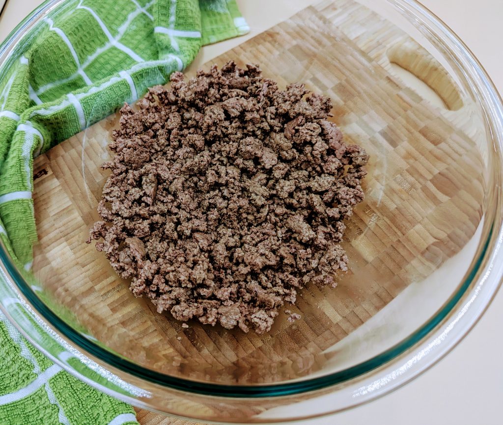 Cooked ground beef in large bowl