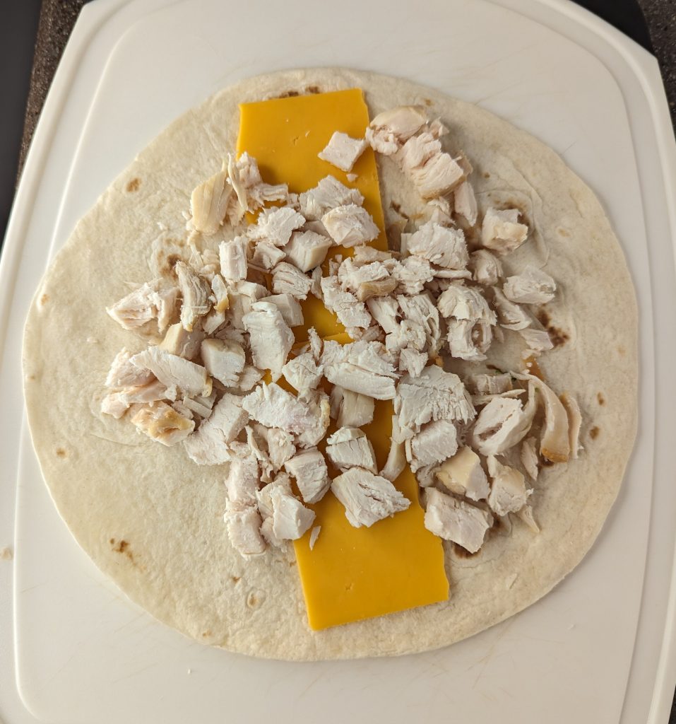 Chciken and cheese on top of tortilla