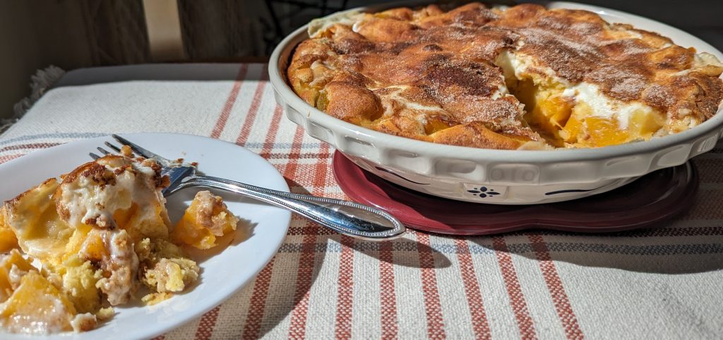 peaches and cream cake with a serving on a plate