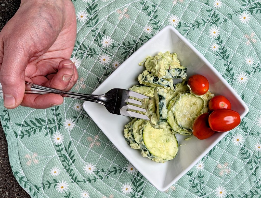 eating a serving of creamy avocado zucchini salad