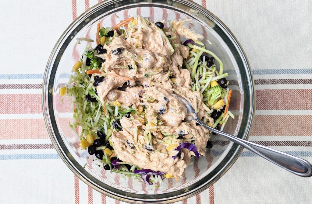 mexican rainbow coleslaw being mixed with dressing