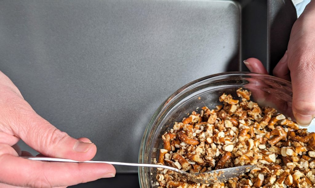 pouring pretzel crust into pan