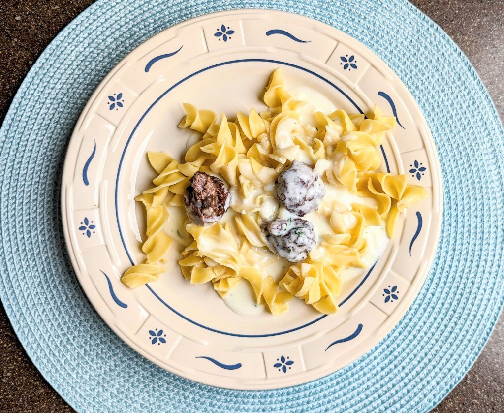 swedish meatballs with dill sauce over noodles