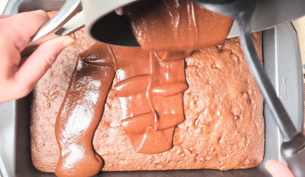 pouring glaze over chocolate covered cherry cake