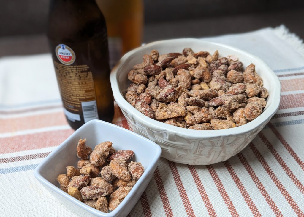 candied mixed nuts with serving bowl and beer