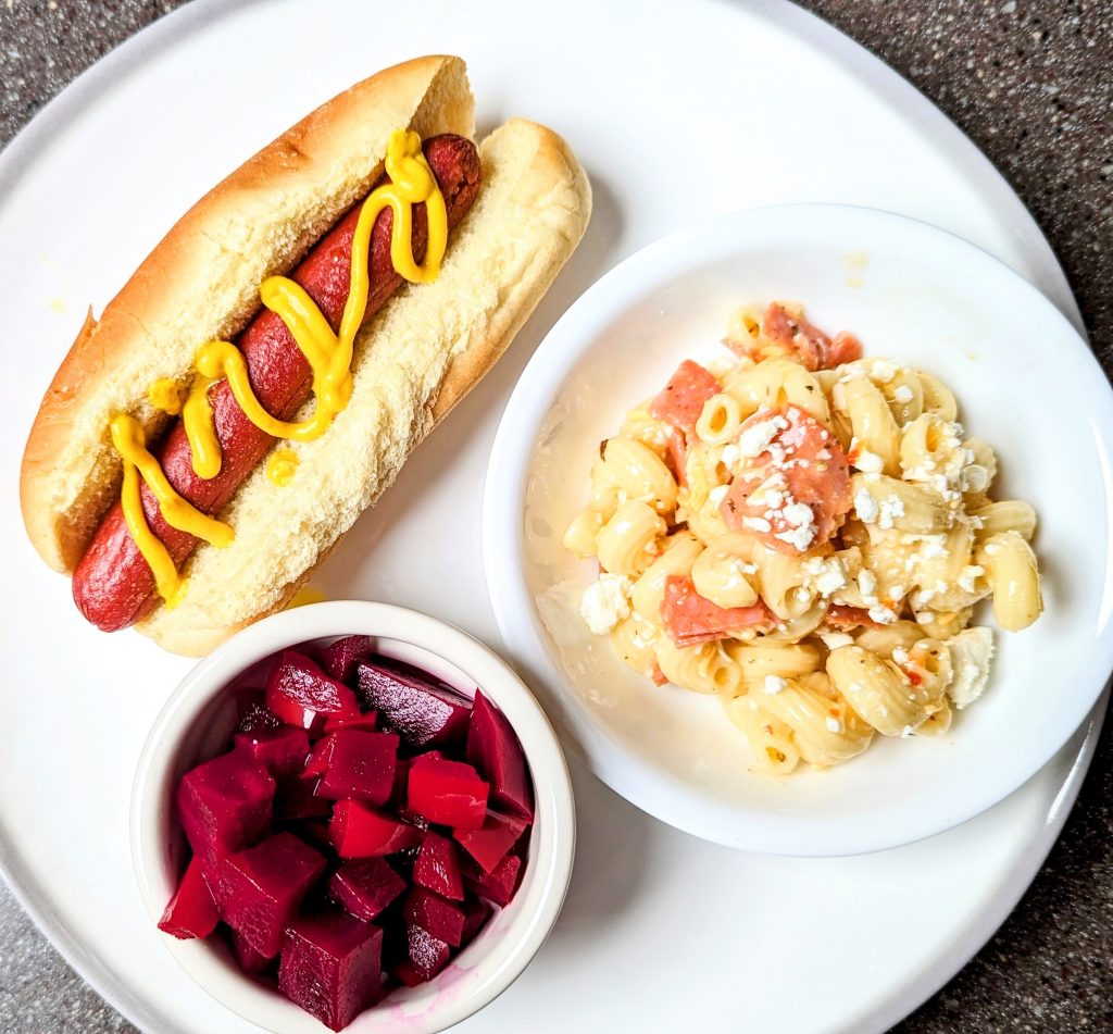 pickled red beet salad on plate with hot dog and pepperoni pasta salad