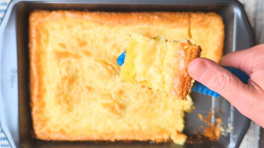 cutting a slice of ooey gooey butter cake