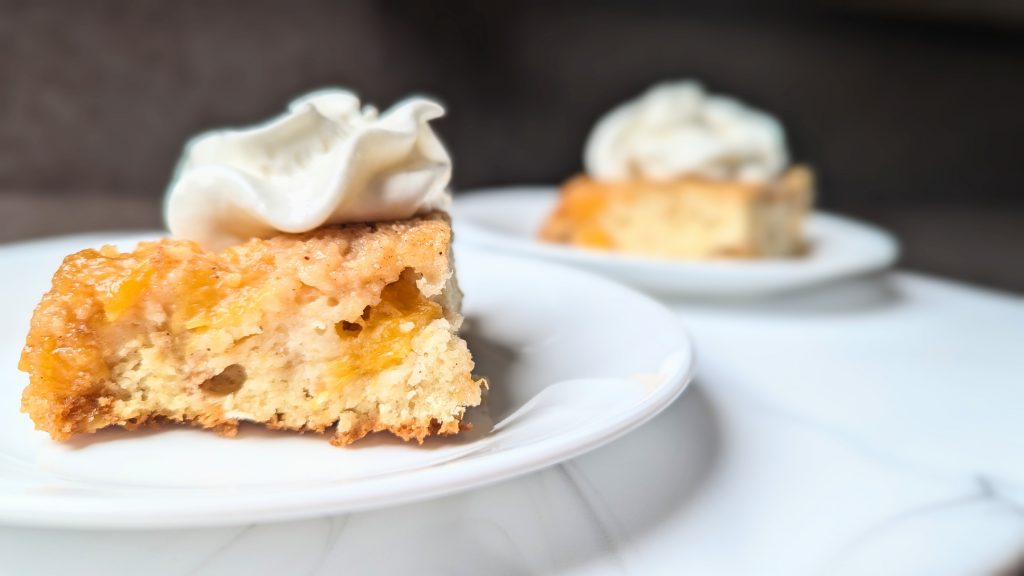 peach upside-down cake on plate with whipped cream