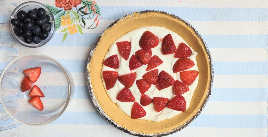 putting berries into summer berry lush pie