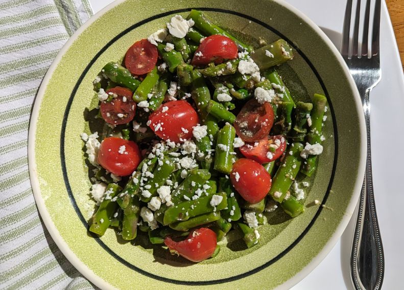 asparagus tomato salad in bowl with fork