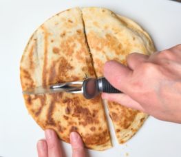 cutting chicken fajita quesadillas with a pizza cutter