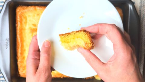 holding a piece of ooey gooey butter cake