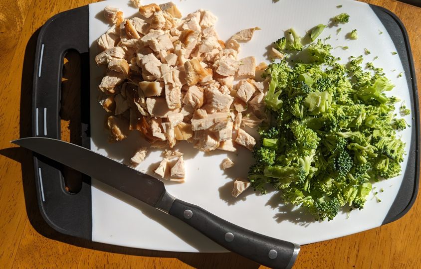 chicken and broccoli on cutting board with knife