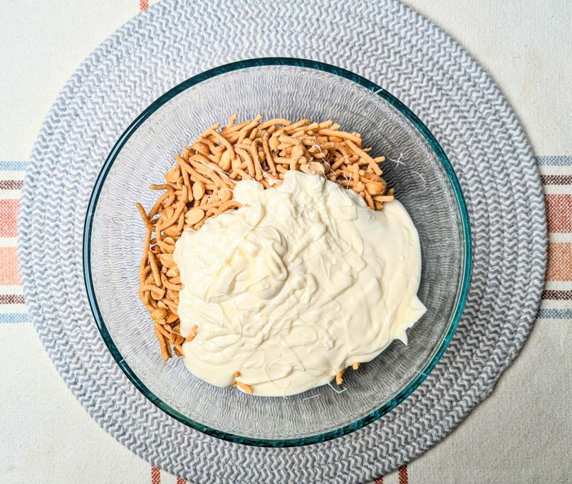 adding melted white chocolate to the bowl