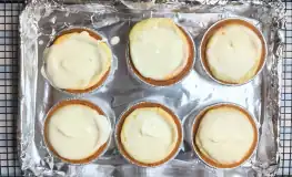 putting topping on cheesecakes