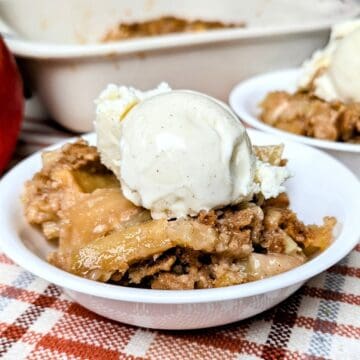 baked apple cobbler from scratch recipe serving in bowl with a scoop of ice cream