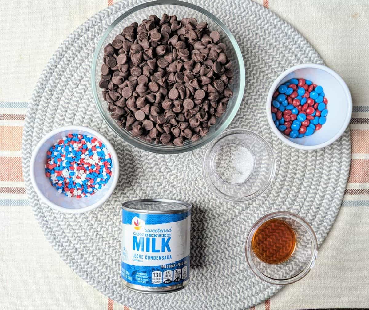 Ingredients for making Patriotic festive fudge including semi-sweet chocolate chips, sweetened condensed milk, and colorful star sprinkles.