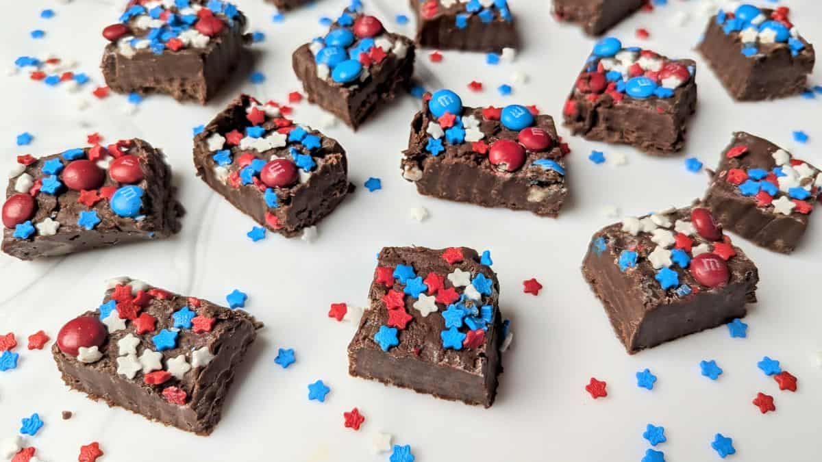 Patriotic festive fudge squares topped with red and blue star sprinkles and mini M&Ms on a festive holiday platter.