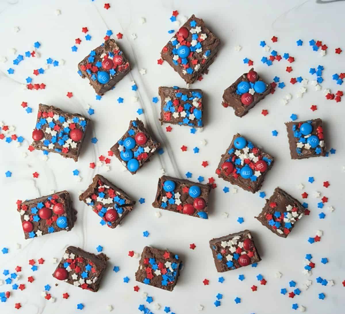 Patriotic festive fudge squares topped with red and blue star sprinkles and mini M&Ms on a festive holiday platter.