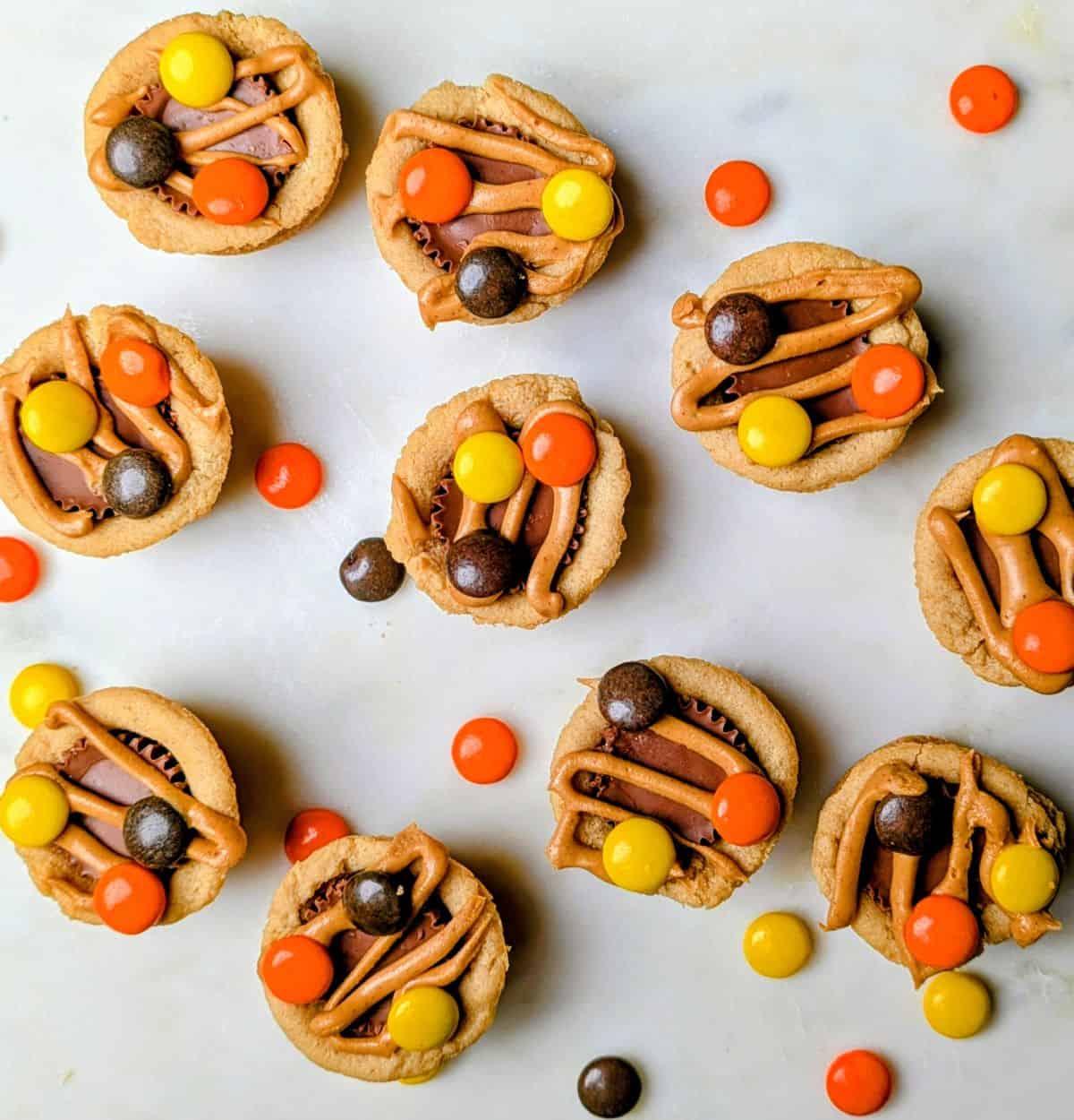 A tray of homemade peanut butter cup cookies topped with colorful chocolate pieces and peanut butter candies.