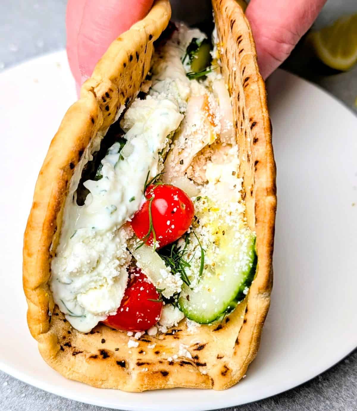 Homemade chicken gyro with tzatziki sauce, tomatoes, and cucumbers wrapped in warm pita bread.