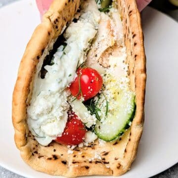 Homemade chicken gyro with tzatziki sauce, tomatoes, and cucumbers wrapped in warm pita bread.