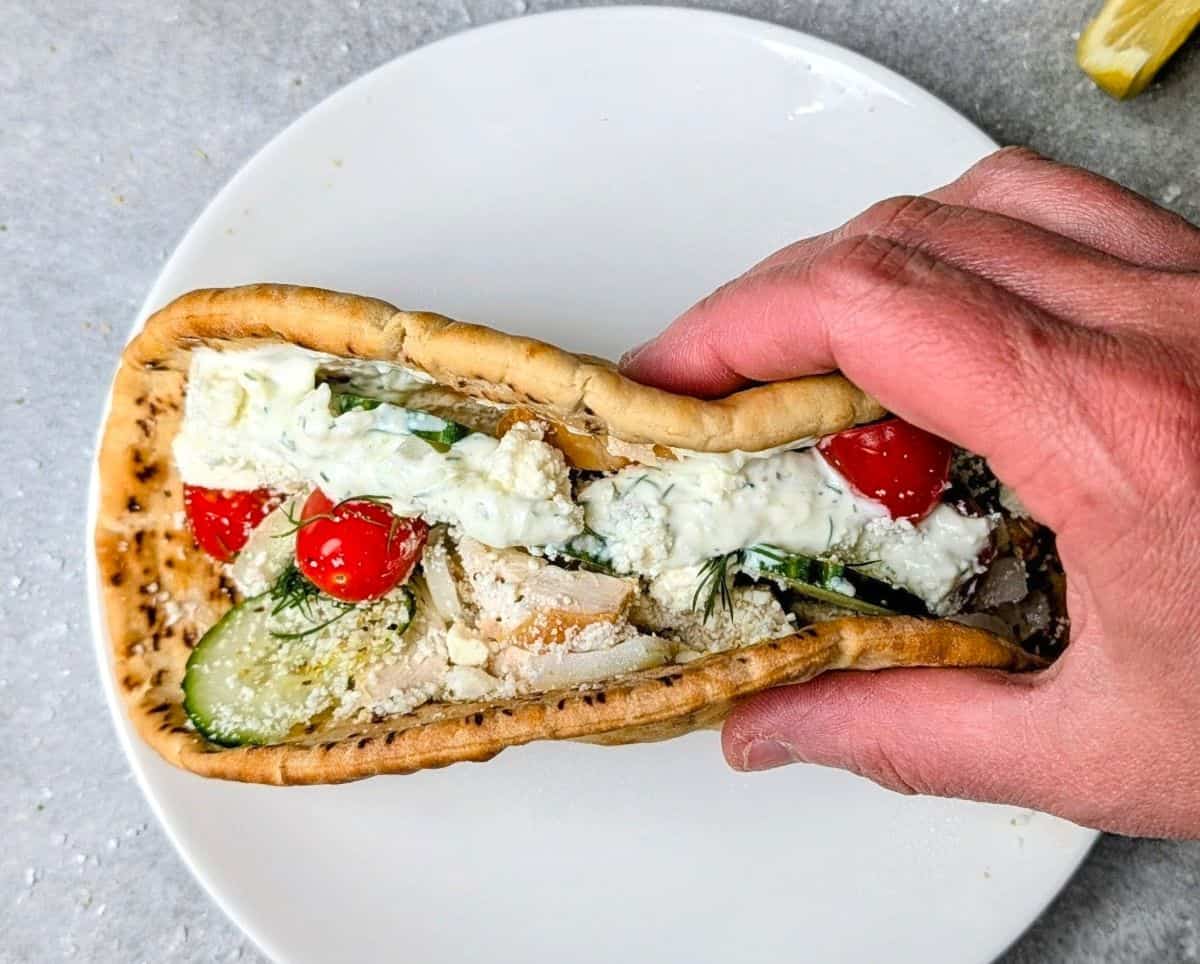 Homemade chicken gyro with tzatziki sauce, tomatoes, and cucumbers wrapped in warm pita bread.