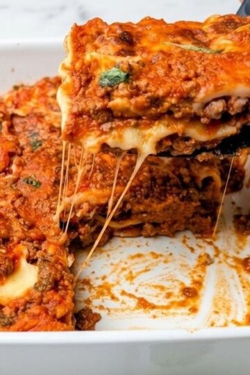 lazy lasagna serving being lifted out of casserole dish with cheese pull