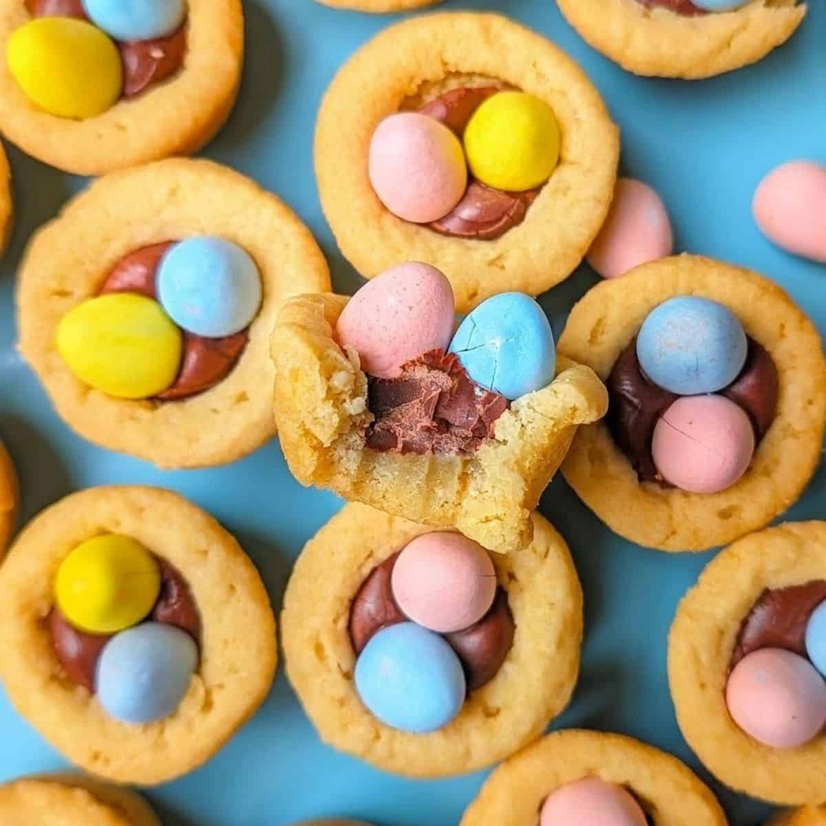 Easter mini egg cookie cups filled with frosting and topped with pastel candy eggs.