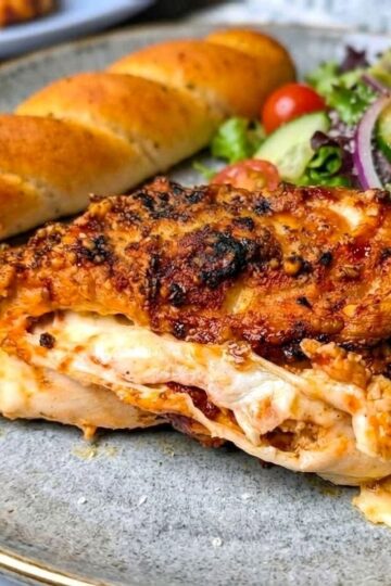 pizza stuffed chicken on plate with salad