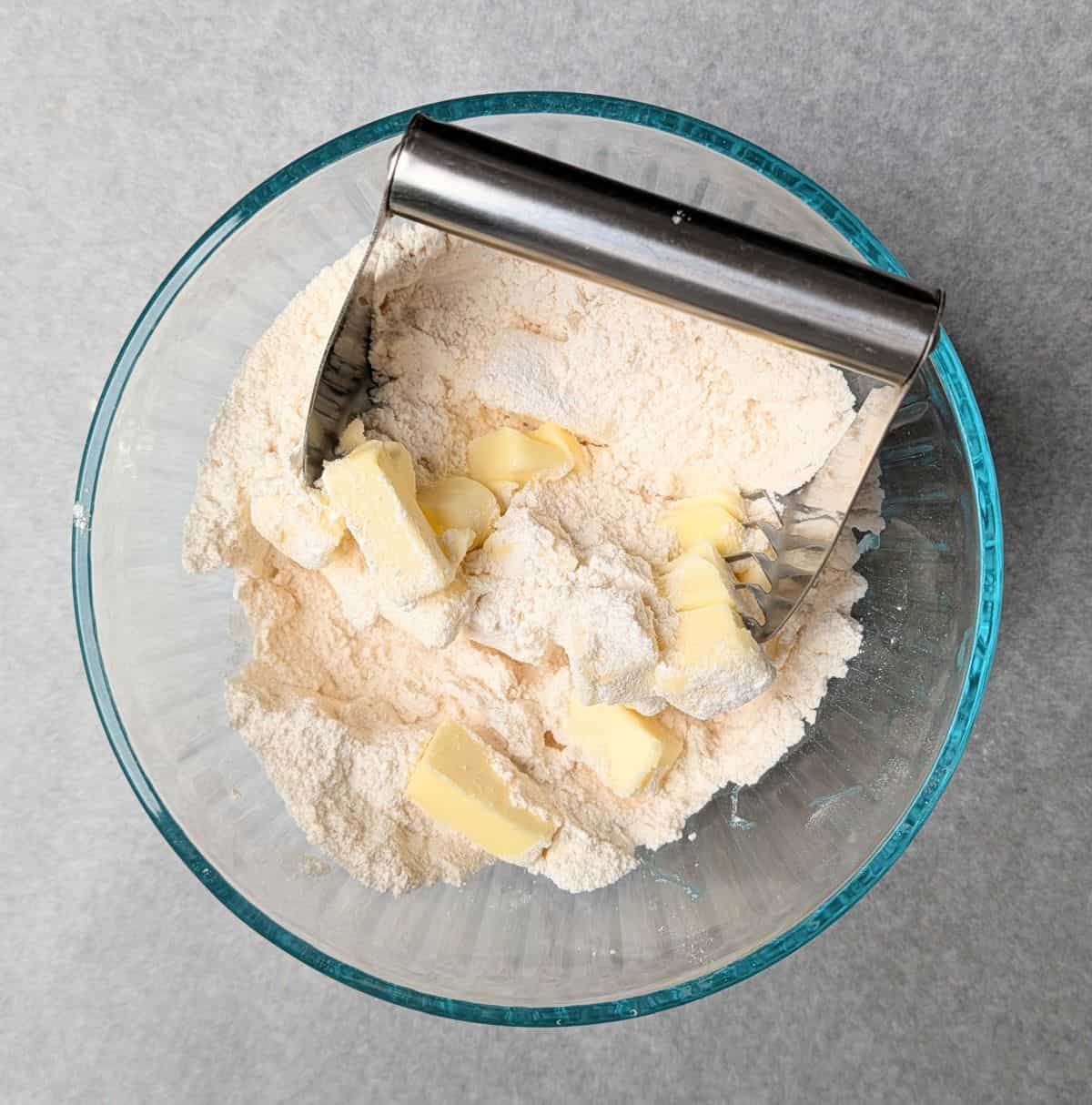 making biscuit topper and cutting butter into it