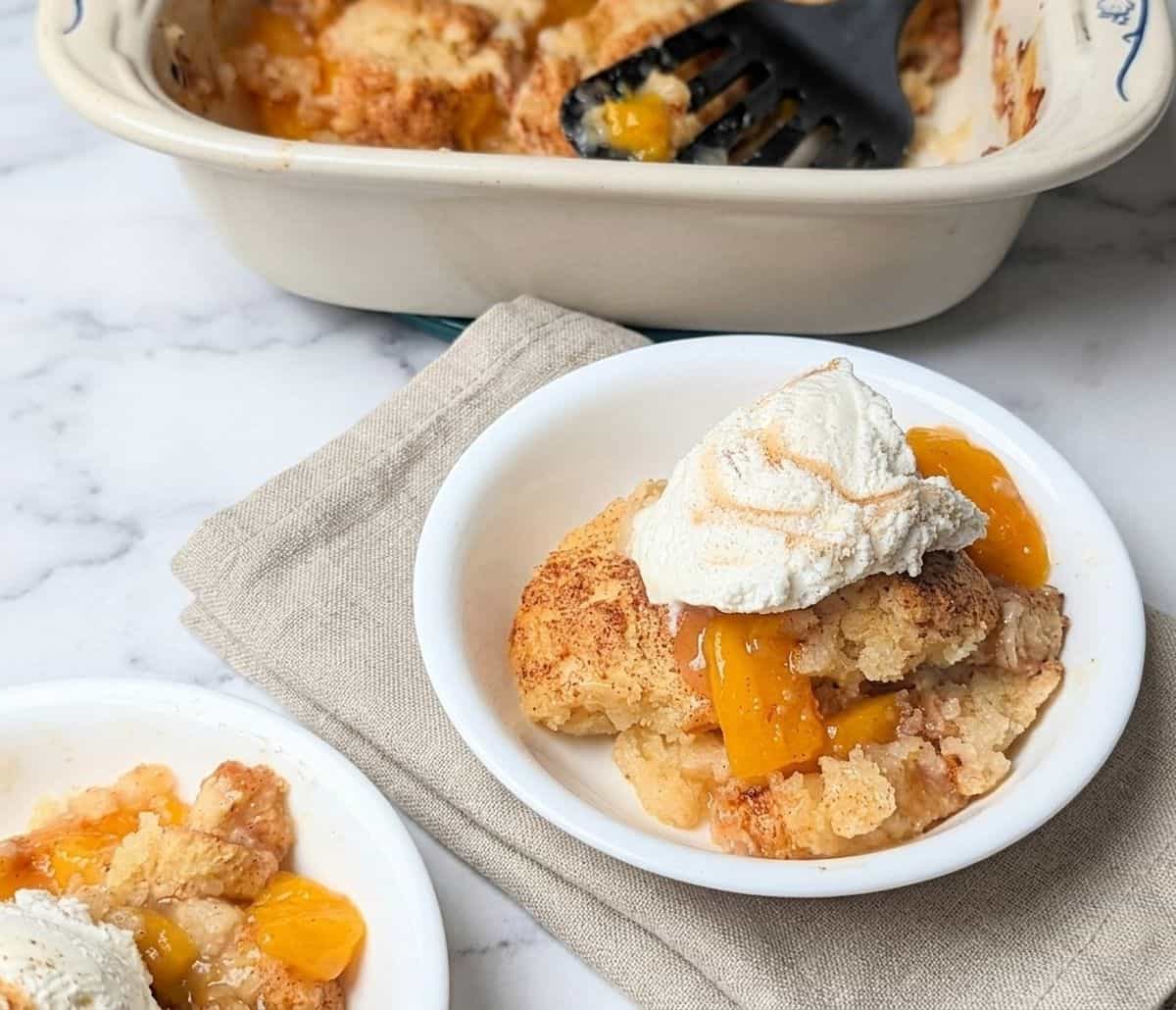 easy peach cobbler servings in bowl with ice cream