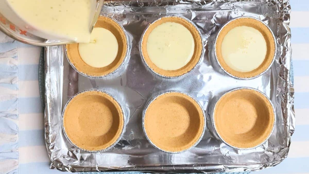 pouring cream cheese mixture into crusts