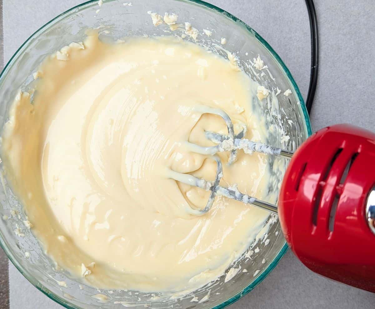 Blending cream cheese, eggs, and sweetened condensed milk for lemon raspberry cheesecake bars.