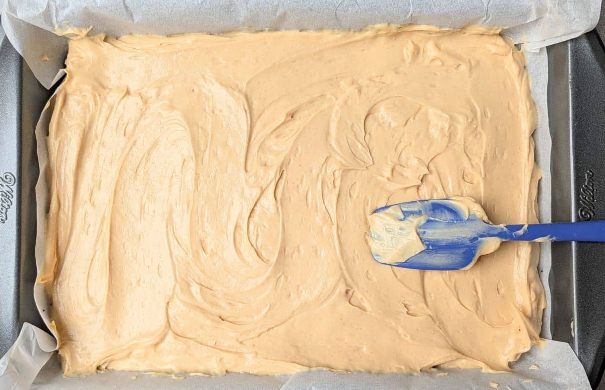 spreading cheesecake mixture over oreo crust