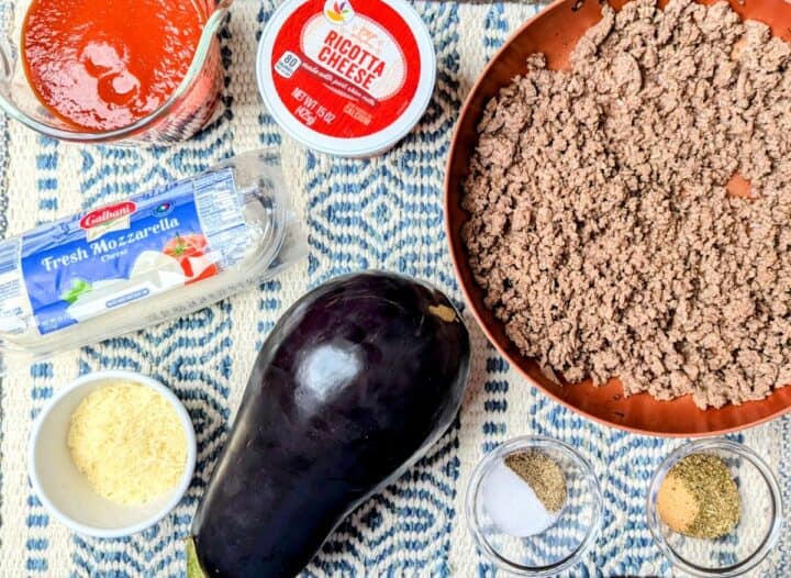 Ingredients for making an easy eggplant casserole, including ground beef, cheeses, and tomato sauce.