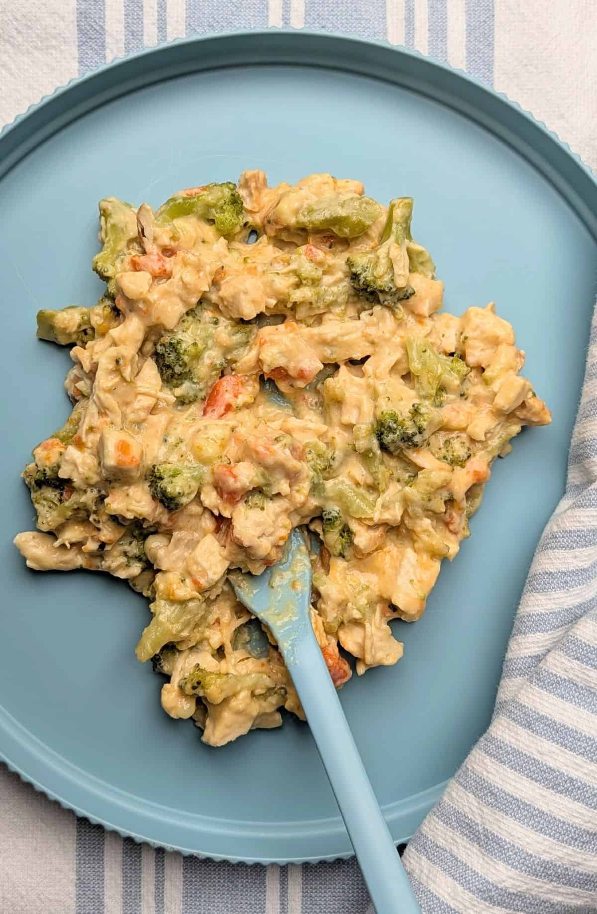 hearty serving of cheesy chicken annd broccoli casserole on plate, easy to see the creamy texture