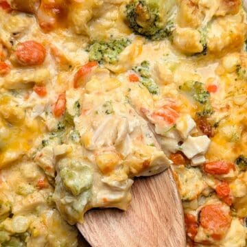 cheesy chicken broccoli casserole being lifted out of dish to serve