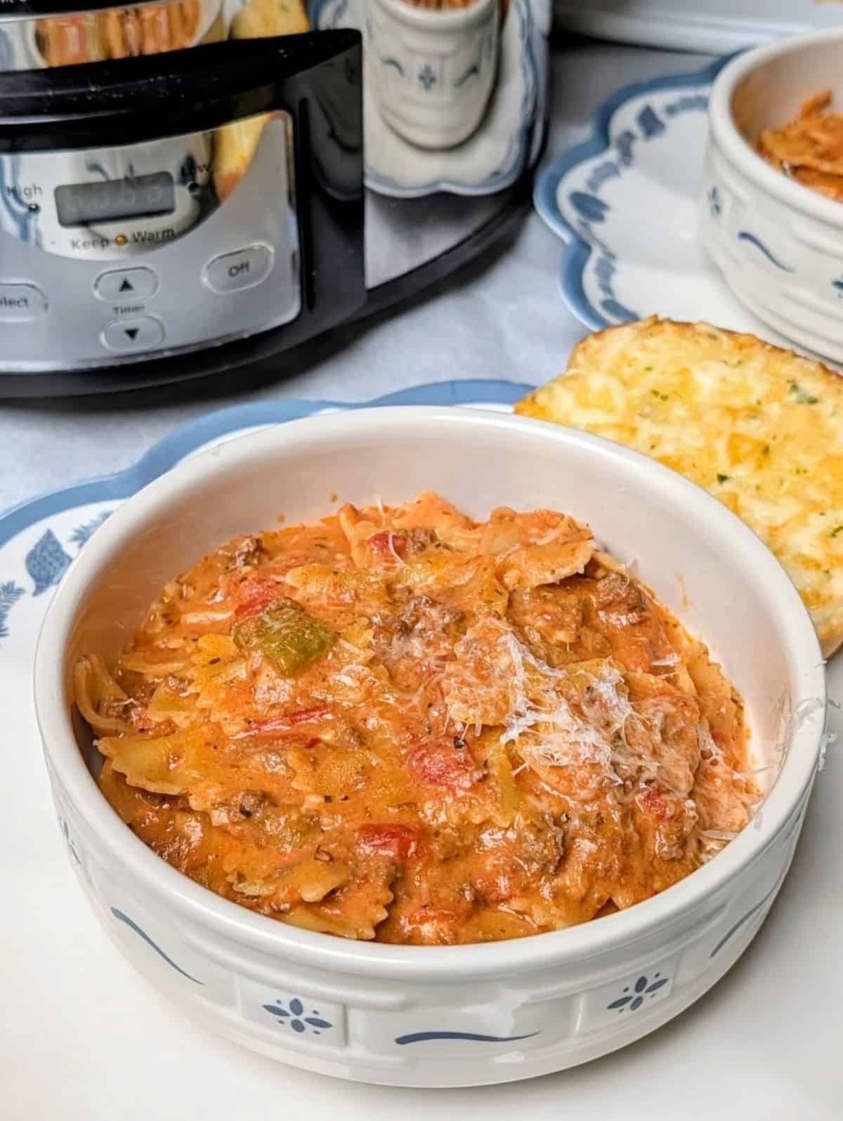 lasagna soup in bowl with crock pot in background