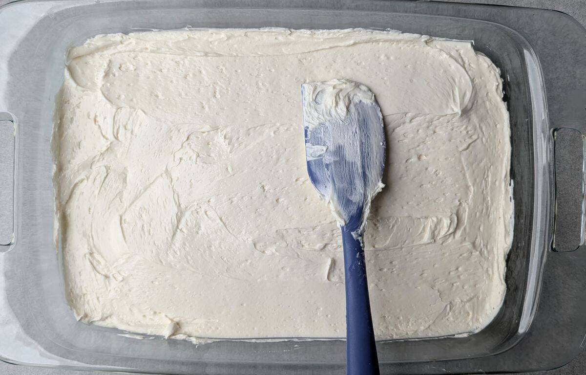 Cream cheese layer spread into a baking dish for this layered dessert.