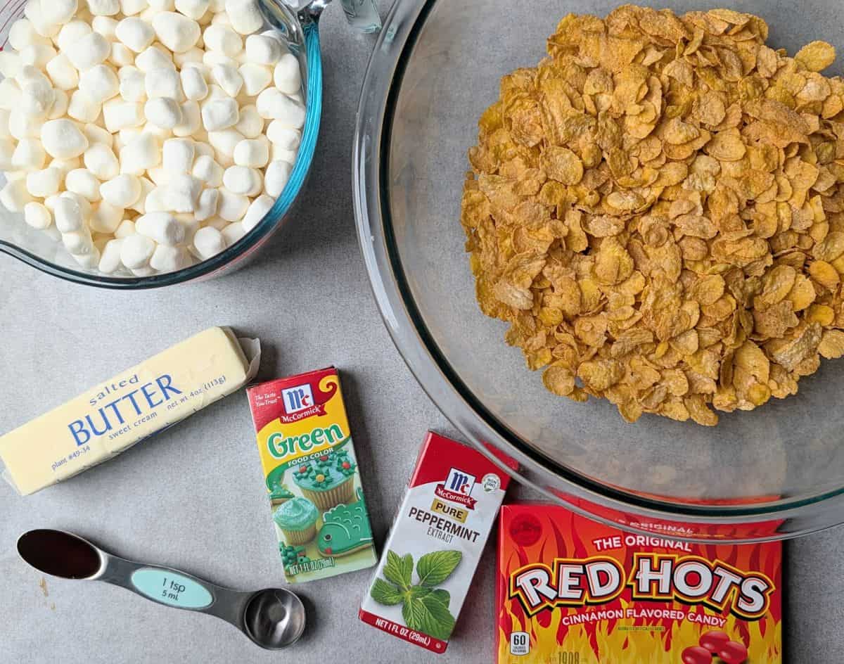 Ingredients needed to make the cookies, featuring marshmallows, green food dye, and red cinnamon candies.