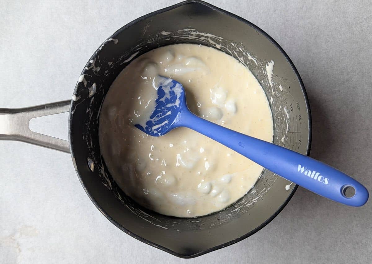 Melting butter and marshmallows in a saucepan to make the sticky base.