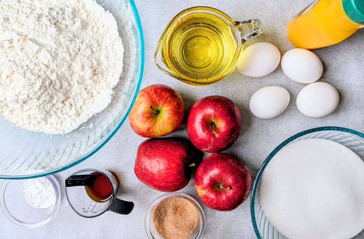 ingredients for cake, including orange juice and fresh apples