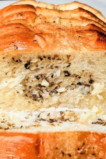 A warm, freshly baked loaf of simple garlic bread sliced and ready to serve.