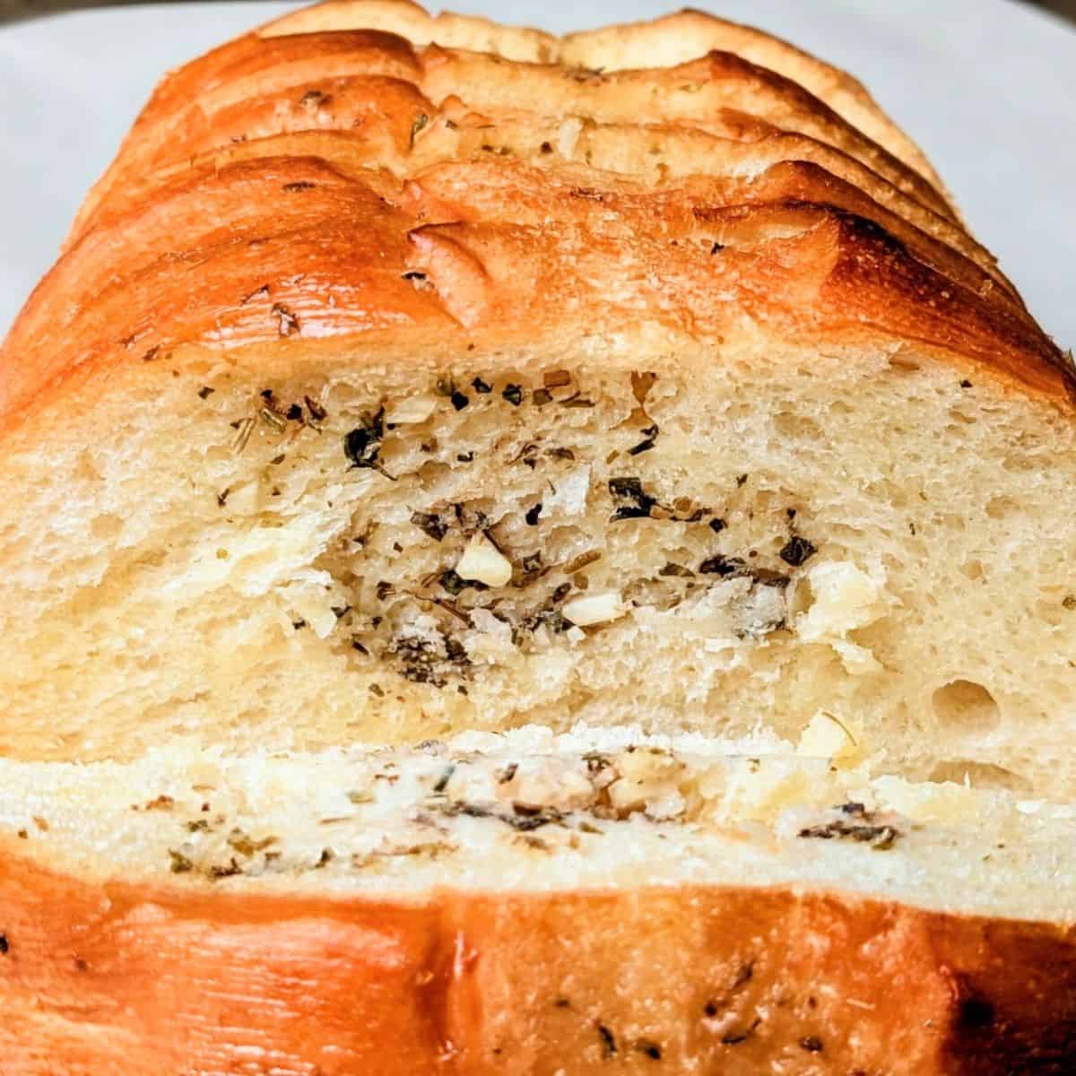 A warm, freshly baked loaf of simple garlic bread sliced and ready to serve.