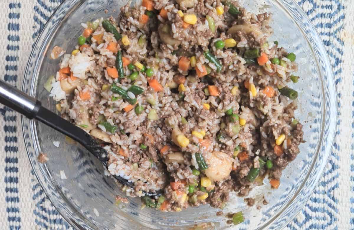 mixing ground beef with rice and other ingredients