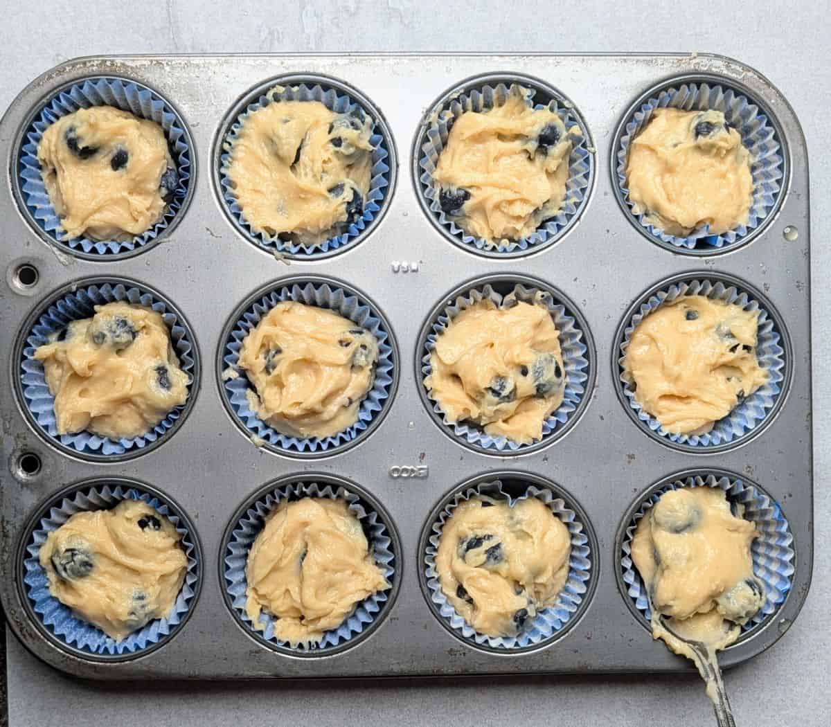 batter added to 12 muffin liners in muffin pan before topping is added