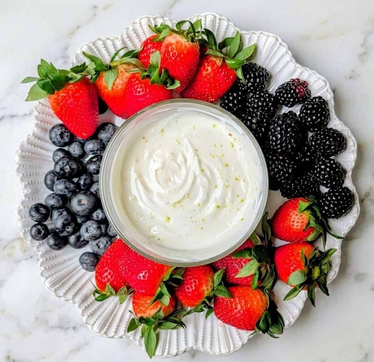 greek yogurt dip on tray with berries