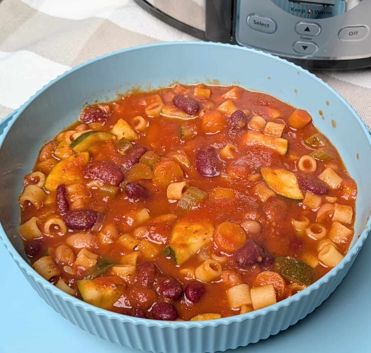 minestrone soup in bowl; slow cooker in background
