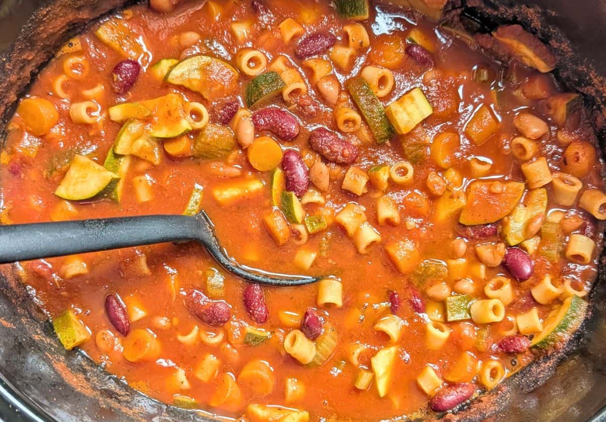 stirring minestrone soup in crockpot